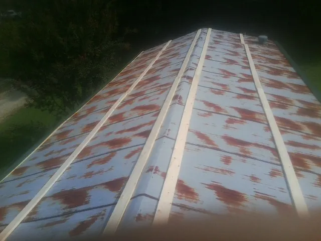 Rusted metal roof panels with new wood purlins before replacement — Storm Damage Roof Repair in Morrow by Roofing Brothers